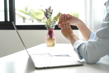 Bileğinde ağrı, avucunda uyuşukluk ve ağrı olan bir kadın elinin sinir uçlarında ağrı ve karıncalanma vardır. Bu ofiste uzun süre oturup çalışmanın bir yan etkisidir..