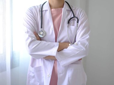 Kadın doktorlar kulaklıkları tutuyor. Hastane koğuşunda duruyorlar. Sağlık sigortası konsepti..