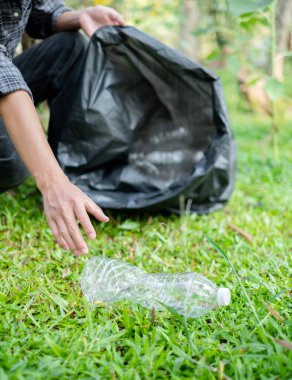 Adamın elleri plastik şişeleri topluyor, çöpleri siyah çöp torbalarına doldurup parkları temizliyor, kirlilikten kaçınıyor, çevreye ve ekosisteme dost oluyor..