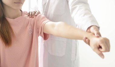 Kadın fizyoterapistler, omuz yaralanması olan hastalara rehabilitasyon merkezinde kas tedavisi için omuzlarına masaj yapıyorlar. Fizyoterapi kavramları.