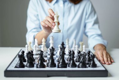 Satranç oynayan iş kadını eli liderlik, takipçiler ve iş dünyasının başarı stratejilerini gösteriyor.