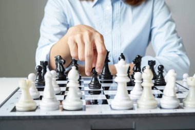 Satranç oynayan iş kadını eli liderlik, takipçiler ve iş dünyasının başarı stratejilerini gösteriyor.