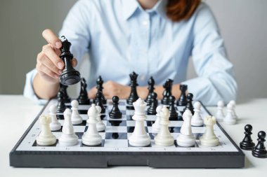 Satranç oynayan iş kadını eli liderlik, takipçiler ve iş dünyasının başarı stratejilerini gösteriyor.