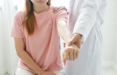 Kadın fizyoterapistler, omuz yaralanması olan hastalara rehabilitasyon merkezinde kas tedavisi için omuzlarına masaj yapıyorlar. Fizyoterapi kavramları.