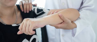 Kadın fizyoterapistler, dirsek yaralanması olan kadın hastalara rehabilitasyon merkezlerindeki hastaları muayene etmeleri için fiziksel yardım sağlıyorlar. Fizyoterapi kavramları.
