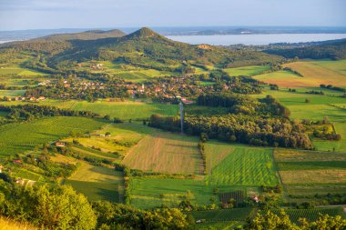 Balaton Highlands, Csobanc 'tan Badacsony ve Szigliget' i izleyin. Günbatımında Balaton Gölü ile Badacsony Tepesi, Macaristan.
