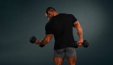 Bodybuilder in black t-shirt lifting weights, shot from the back