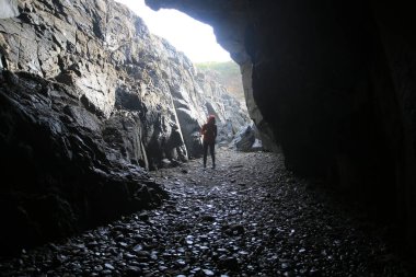 Gizemli kadın mağaranın içinde duruyor.