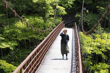 Kız köprüde, Japonya 'da, Kinugawa' da, Tochigi 'de yürüyor.