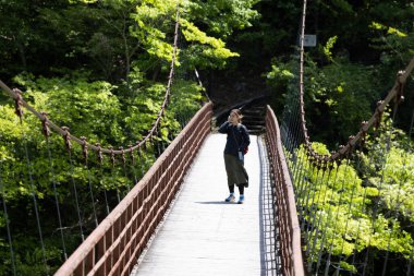 girl walk around on the suspension bridge, near kinugawa onsen, a touchigi countryside