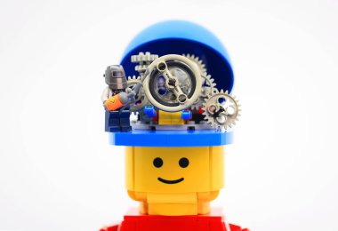 Hong Kong - 2 Eylül 2023: Küçük işçi dev adamın kafasındaki dişli tekerlekleri tamir etti