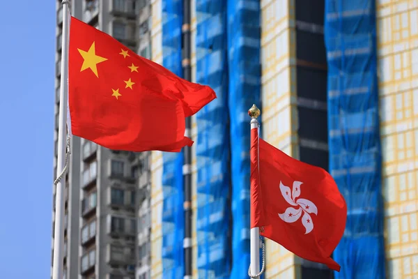 Chinese and hong kong flag set up in the event for celebrating the National Day of the People\'s Republic of China 74 th anniversary with the real estate background