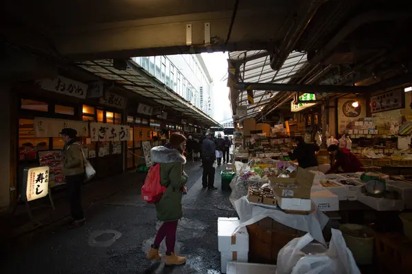 Tokyo, Japonya - 15 Ocak 2018: Tsukiji Pazarı 'ndaki yemek caddesini ziyaret eden turist. Haziran 2017 'de balık pazarının taşınma planları yeniden başlatıldı ancak Temmuz 2018' de sonbahara ertelendi.