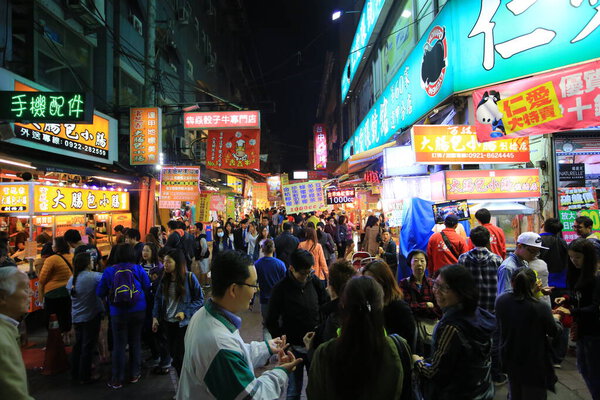 Тайчжун; Тайвань, 14 апреля 2015 года: неизвестные покупают продукты питания на улице на ночном рынке Астаны. Индонезия - один из знаменитых ночных рынков Тайваня