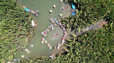 Turistler Hoi An, Vietnam 'daki Hindistan Cevizi Ormanı Basket Teknesi Turu' na katılıyor. Vietnam Coracle olarak da bilinen bsaket teknesi, yerel bir taşımacılık ve balıkçılık teknesidir.