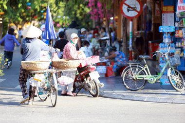 Hoi An, Vietnam 7 Temmuz 2024: Çekçek şoförü sokakta turist arıyor. Eski kasaba, 15. yüzyıldan 19. yüzyıla kadar uzanan bir Güneydoğu Asya ticaret limanı..