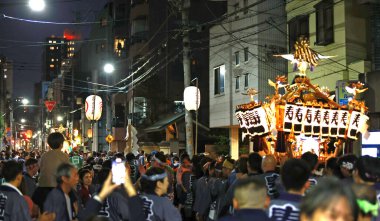 Tokyo - 18 Mayıs 2024: Katılımcılar Sanja Festivali 'nde küçük ölçekli bir türbenin ticaret odalarını temsil ettiği retro sargı giyip tahtırevanı taşıyorlar. Sanja Festivali geleneklerden biri.