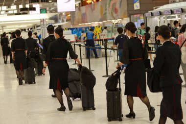 Tokyo 25 May 2023: JAL flight attendants walk through the terminal of Haneda Airport after work. JAL airline is one of famous airline in Japan clipart
