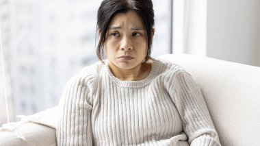 Kadın evde rahatsız ve tatminsiz.