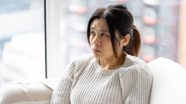 Kadın evde rahatsız ve tatminsiz.