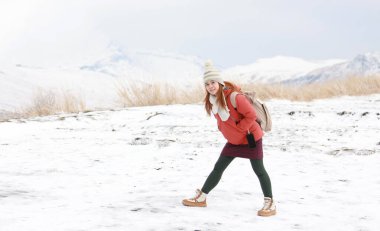 a girl travel to Kusasenri in winter and walk on the peak clipart