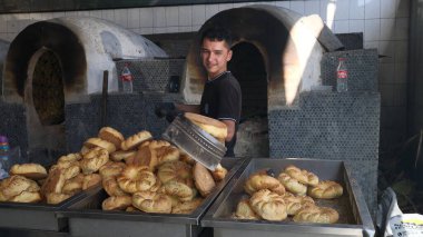 Taşkent, Özbekistan - Ekim 12024: Fırıncı Orta Asya Plov Merkezi 'ndeki Tandyr' dan ekmek yapıyor. 