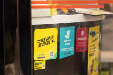 Hong Kong - 31 Mart 2025: Deliveroo HK, Foodpanda ve Keeta etiketi Hong Kong 'daki restoranın tezgahında. Nisan 2025 'e kadar üç gıda dağıtım şirketi var.