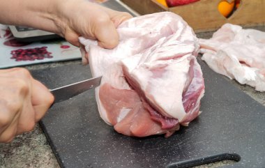 a close up of woman hands cutting meat 