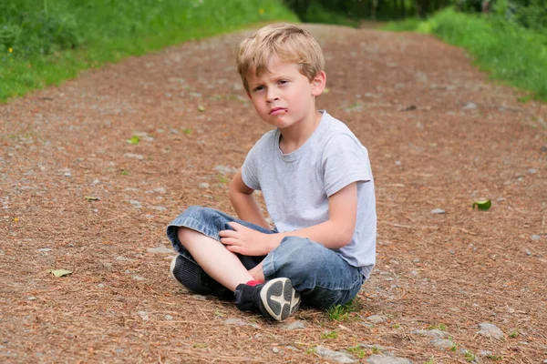 自然界に一人で座っている少年の肖像画です — ストック写真