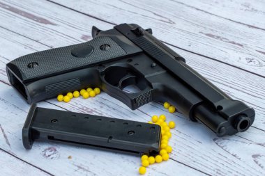 Beyaz ahşap arka planda sarı panjurlu yumuşak bir tabanca.