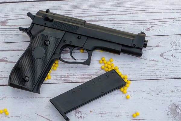 Beyaz ahşap arka planda sarı panjurlu yumuşak bir tabanca.