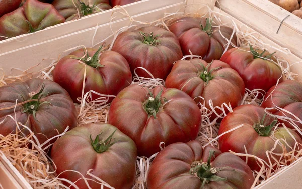 wooden crate of beef tomatoes on the market