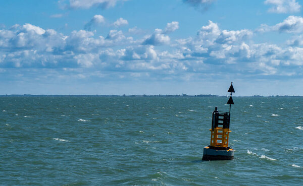 Yellow and black steel navigational floating buoy ,  a cardinal mark