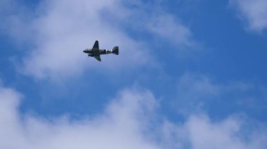 Antik askeri jet mavi bulutsuz gökyüzünün üzerinde gökyüzünde uçar. Saint Come du Mont, Normandiya, Fransa
