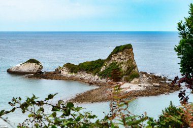 Okyanusun ortasında kayalık bir ada var. Su sakin ve gökyüzü açık, Saint Jean de Luz, Fransa