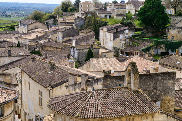A small town with many houses and a few trees. The houses are made of stone and have roofs
