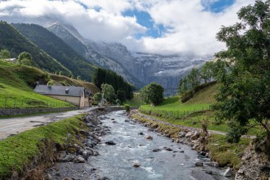 The Cirque of Gavarnie, french Pyrenes mountains. The mountains are covered in snow and the sky is cloudy clipart