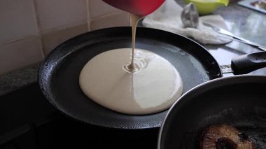 Mutfakta tavada elmalı börek pişirmek.