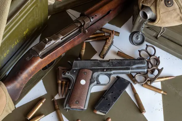 Masada bir silah ve bir sürü mermi var. Silah bir tüfek ve mermiler de bir yığın içinde.