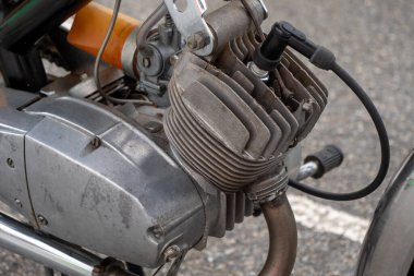Motosiklet mühendisliği. Motor siyah ve gümüşten yapılmış. Eski ve yıpranmış.