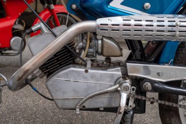 Motosiklet motoru siyah bir zincir ile gösterilir. Zincir arka tekere bağlı.