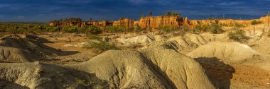 Desert Tatacoa 'nın panoramik manzarası - Desierto de la Tatacoa, Huila Kolombiya. Gün batımında kaktüslerle kaplı inanılmaz kuru manzara, dramatik bulutlu gökyüzü. Kuru tropikal orman. 