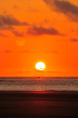 Manab, Ekvador 'daki Cojimes plajında gün batımının önünden küçük bir tekne geçiyor..