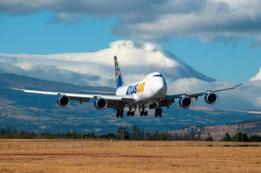 Atlas Air Boeing 747 'nin görkemli Cotopaxi Volkanı' nın arka planda kısmen bulutlarla kaplandığı son iniş aşamalarındaki çarpıcı görüntüsü..