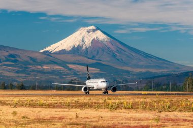 Arkadaki Cotopaxi yanardağı ile birlikte Mariscal Sucre Havalimanı 'ndan kalkmaya hazır bir Avianca yolcu uçağı..
