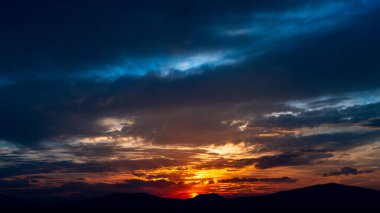 Güneşli bir gün batımı ve Patzcuaro, Michoacan, Meksika 'daki dağların arkasına giden güneş. Fotoğraf Yunuen Adası 'ndan çekildi..