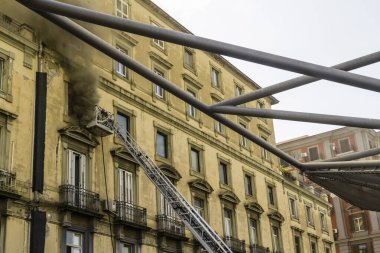 Napoli, İtalya - 15 Şubat 2023 - Pencereden duman yükselen ev yangını. Garibaldi Meydanı, Napoli, İtalya. Garibaldi İstasyonu 'ndan iki itfaiyeciyle itfaiye sepetine ya da kafese.