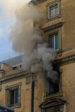 Pencereden duman çıkan bir ev yangını. Garibaldi Meydanı, Napoli, İtalya, Portre