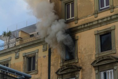 Pencereden duman çıkan bir ev yangını. Garibaldi Meydanı, Napoli, İtalya, manzara