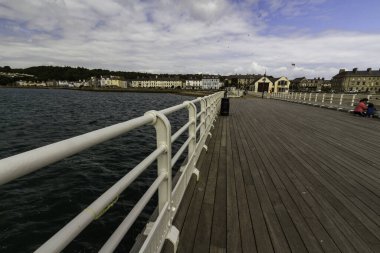 BeaUMARIS, WALES 12 HAZİRAN 2022 Geniş rıhtım açısı ve ön planda el rayları ve RNLI Filika İstasyonu, Beaumaris, Birleşik Krallık ve deniz manzarası